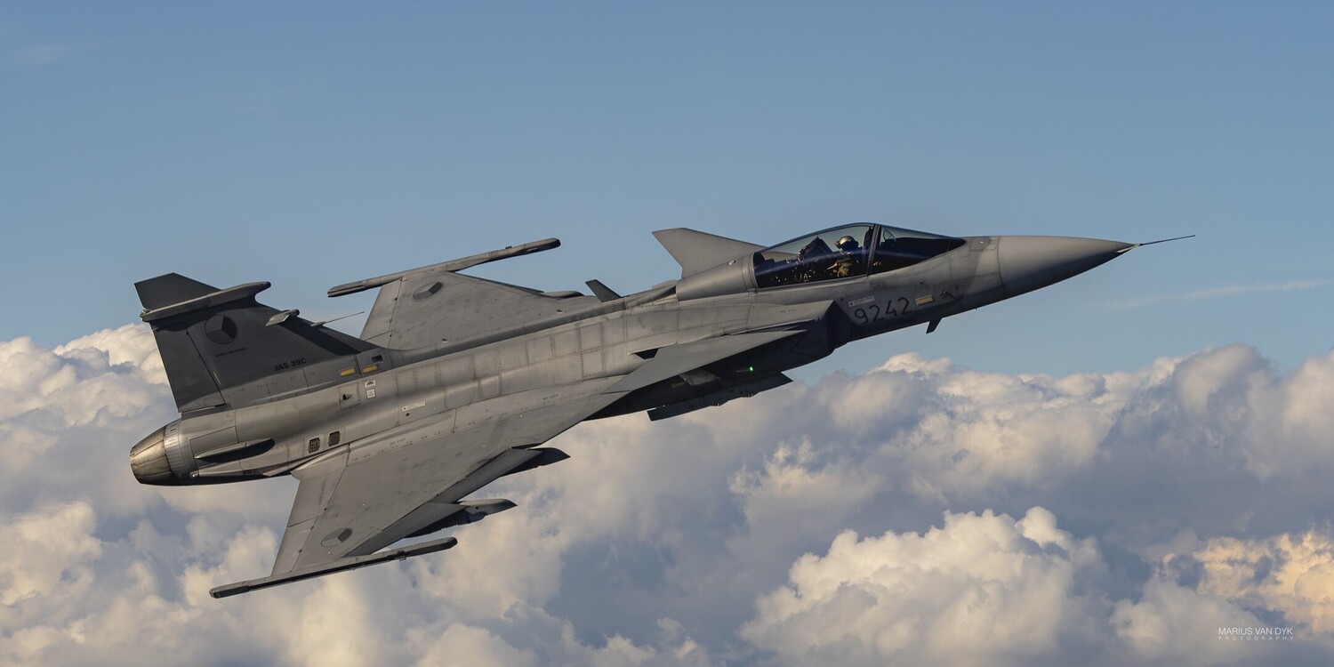 Modern fighter jet in flight against cloudy sky backdrop