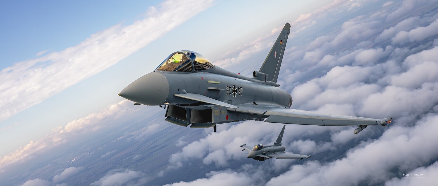 Eurofighter Typhoon jet fighter in flight above clouds with wingman visible in background