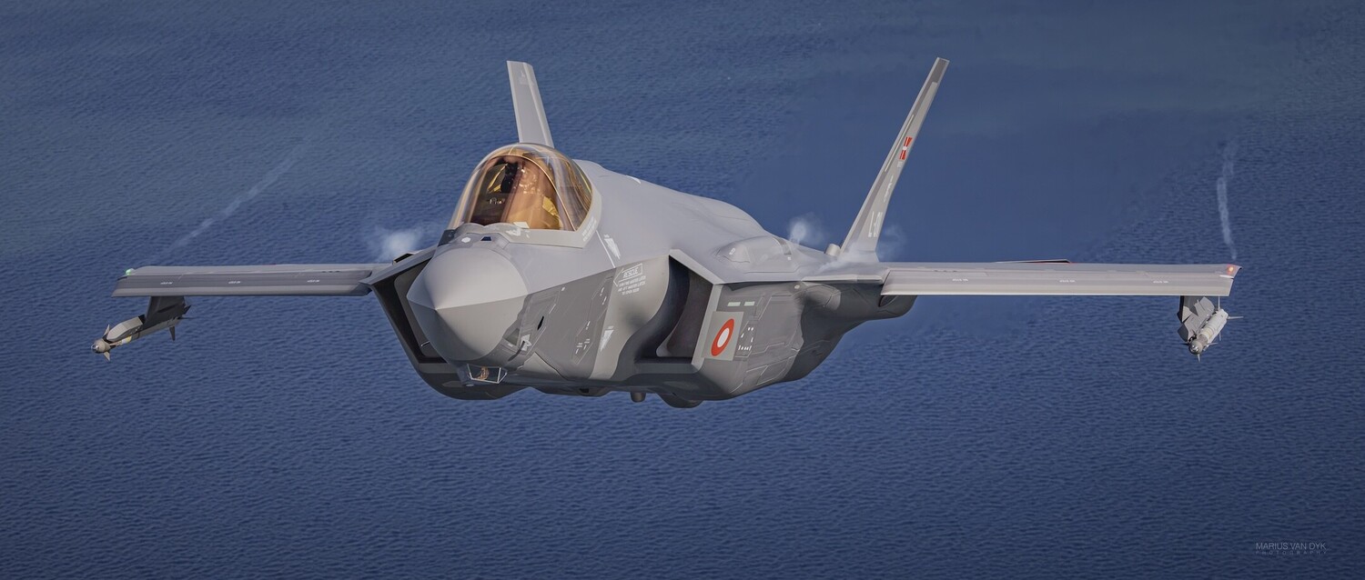 Grey F-35 Lightning II stealth fighter jet with a Japanese roundel, flying low over blue ocean