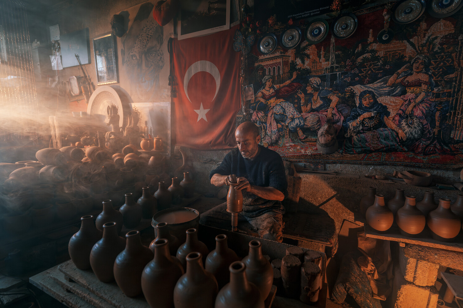 Craftsman working among traditional pottery vessels in a workshop with warm lighting