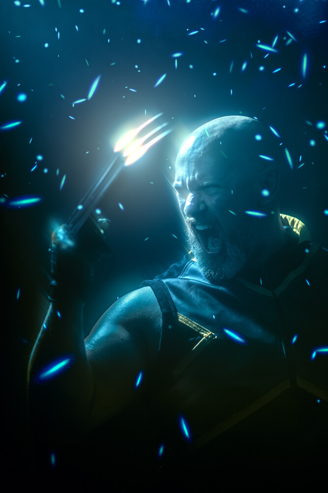 Male figure surrounded by glowing blue particles and light streaks in dark studio lighting