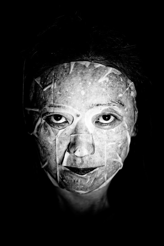 High-contrast black and white portrait of a face with geometric line overlays creating fragmented sections