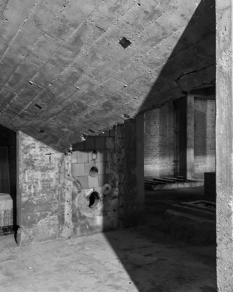 Concrete brutalist corridor with dramatic shadows and recessed lighting fixtures