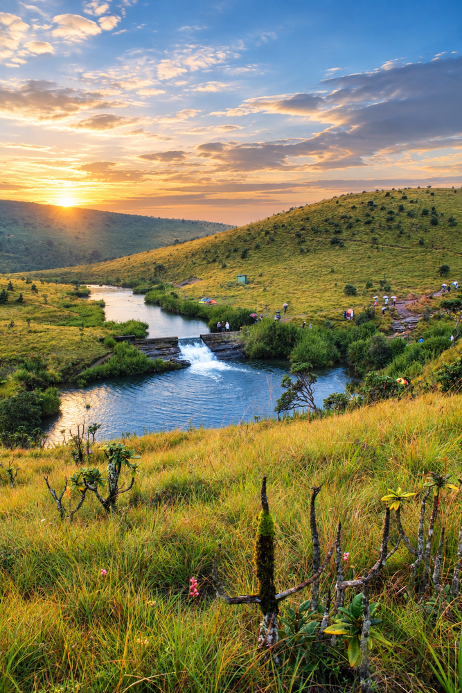 Golden hour landscape with meandering river through green valley and forested hills