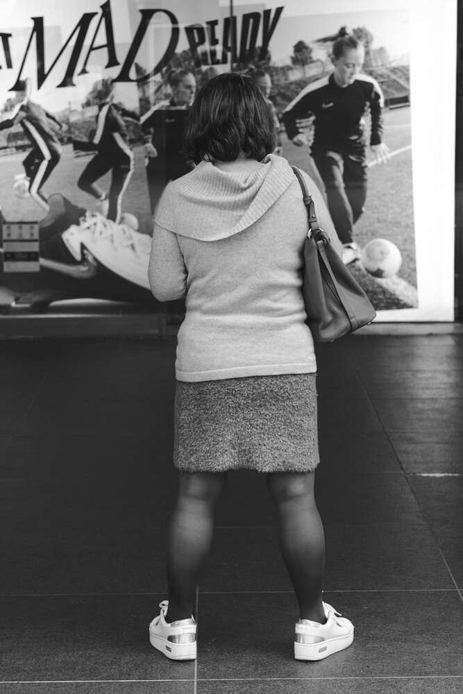 Woman from behind viewing a black and white photograph on a gallery wall