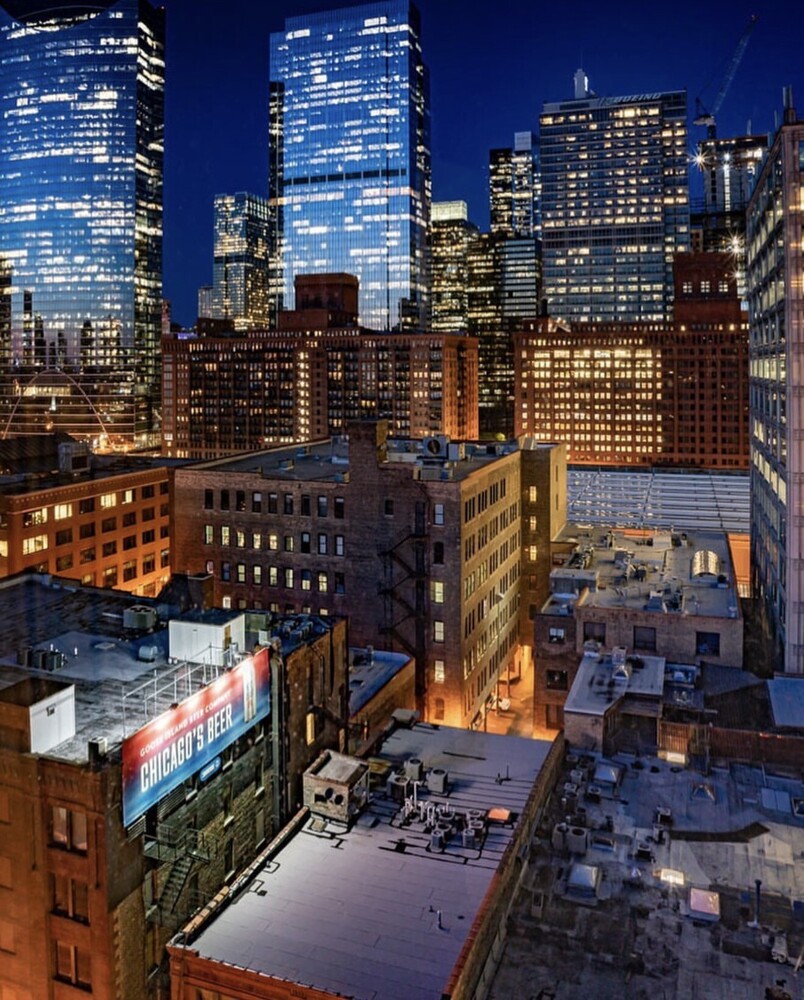Manhattan skyline at dusk with illuminated skyscrapers and street-level urban buildings