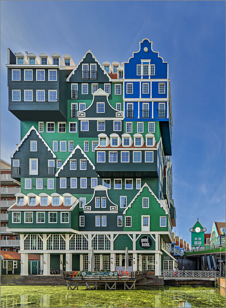 Stacked colorful Dutch-style buildings with geometric facades and varied roof lines against blue sky