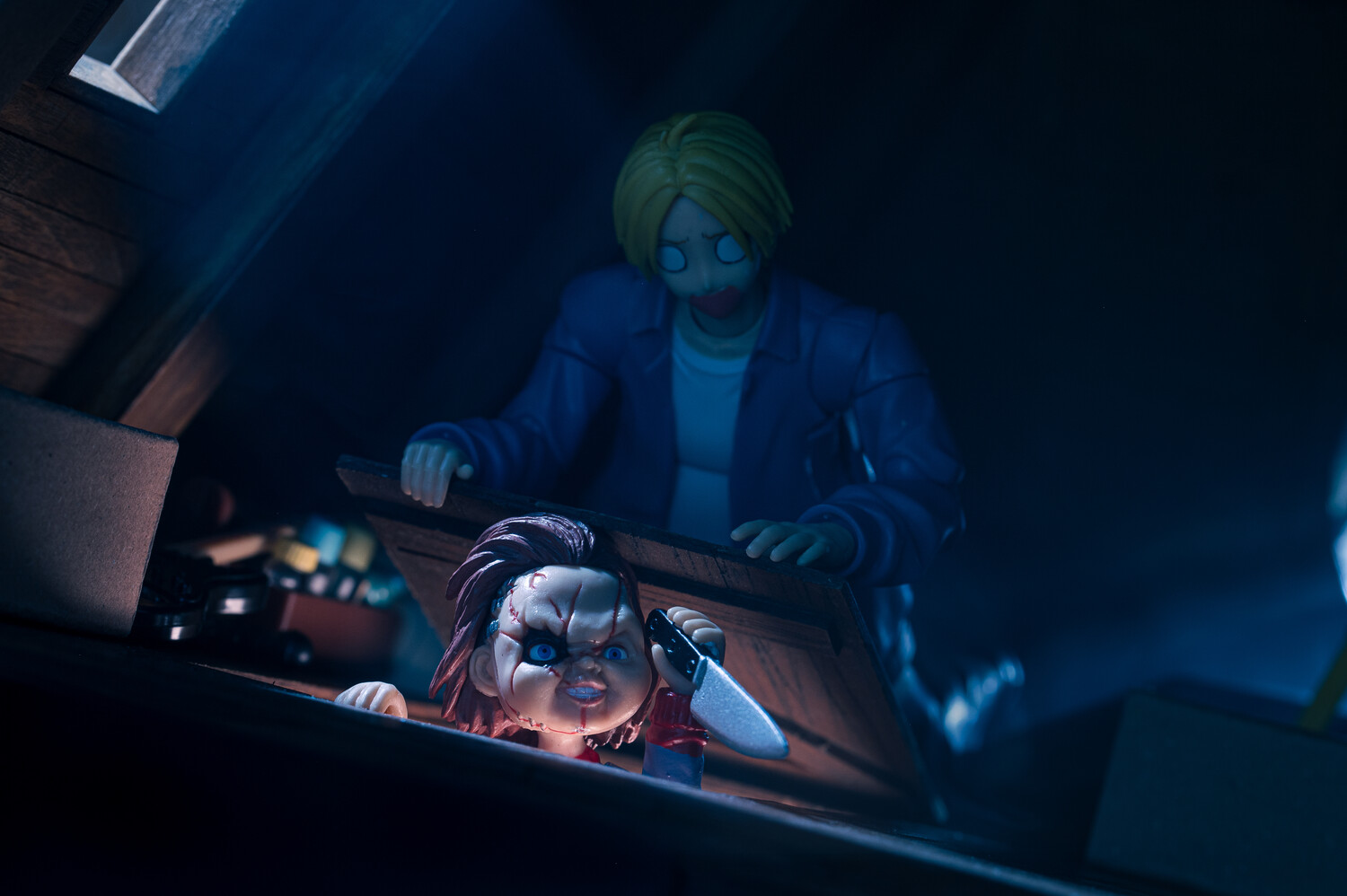 Two figures illuminated by blue and green gel lighting working at a control panel in darkness