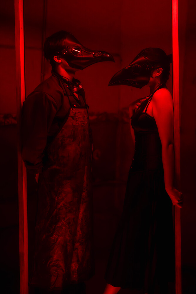 Two figures in silhouette posed facing each other within a red neon-lit frame