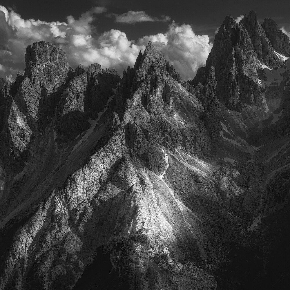 Dramatic black and white mountain landscape with jagged peaks and clouds