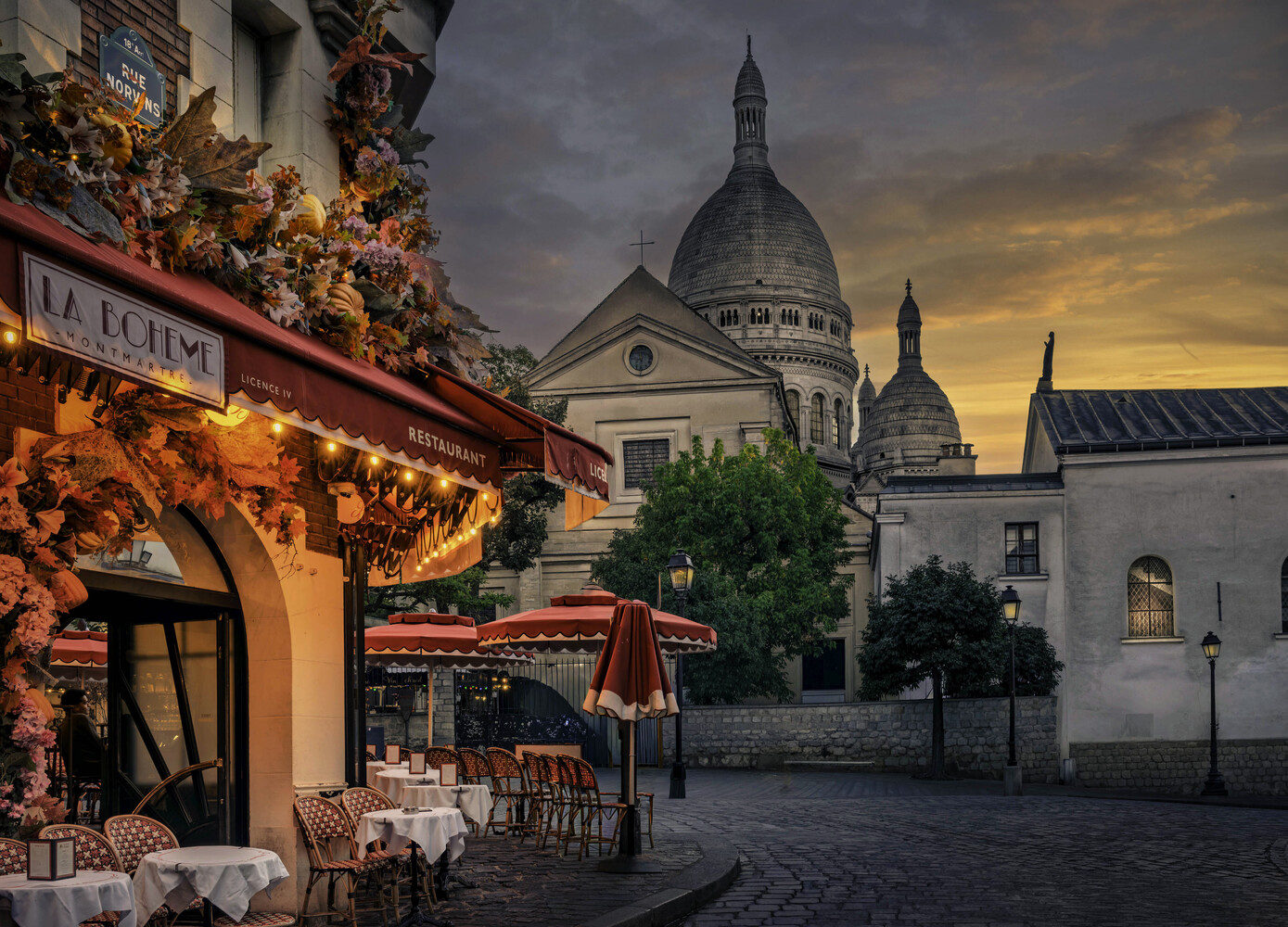 Sacré-Cœur Basilica at dusk with a red-awninged café in the foreground
