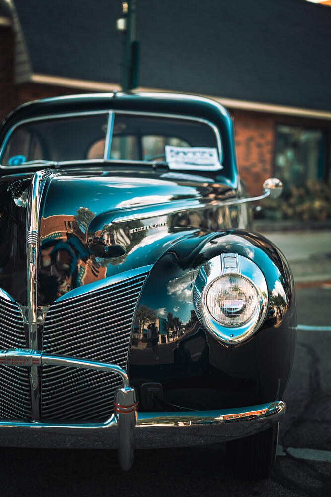 Front view of a restored vintage car with chrome details and rounded headlight