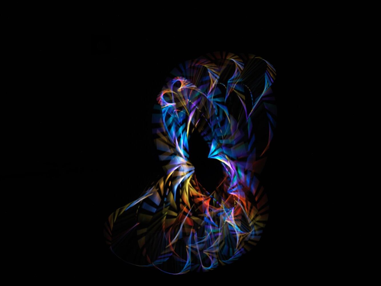 Abstract light painting silhouette with vibrant blue, orange, and purple neon trails against black background