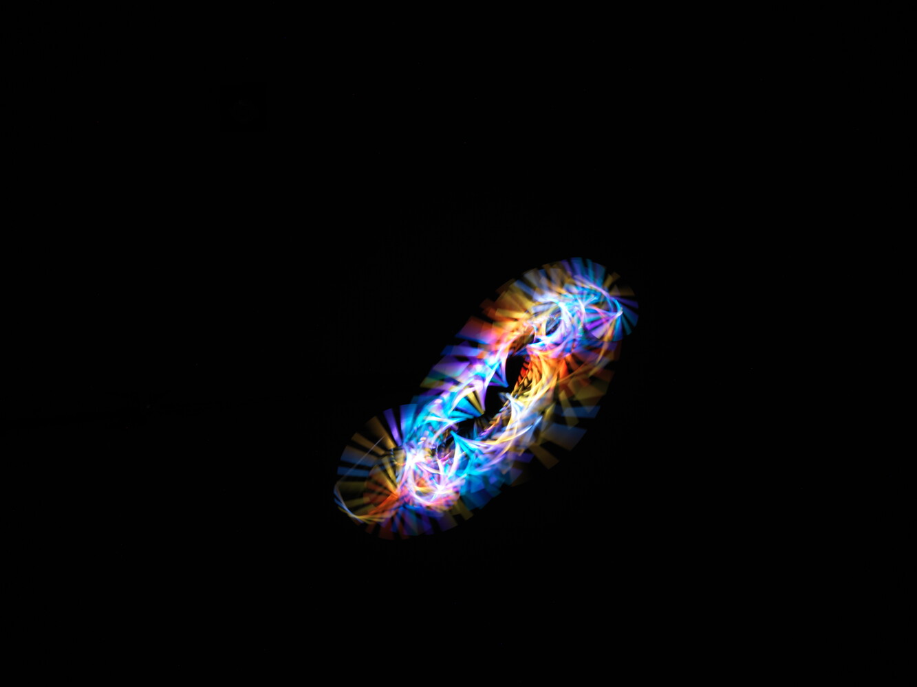 Bioluminescent organism with glowing blue, purple, orange, and yellow segments against black background
