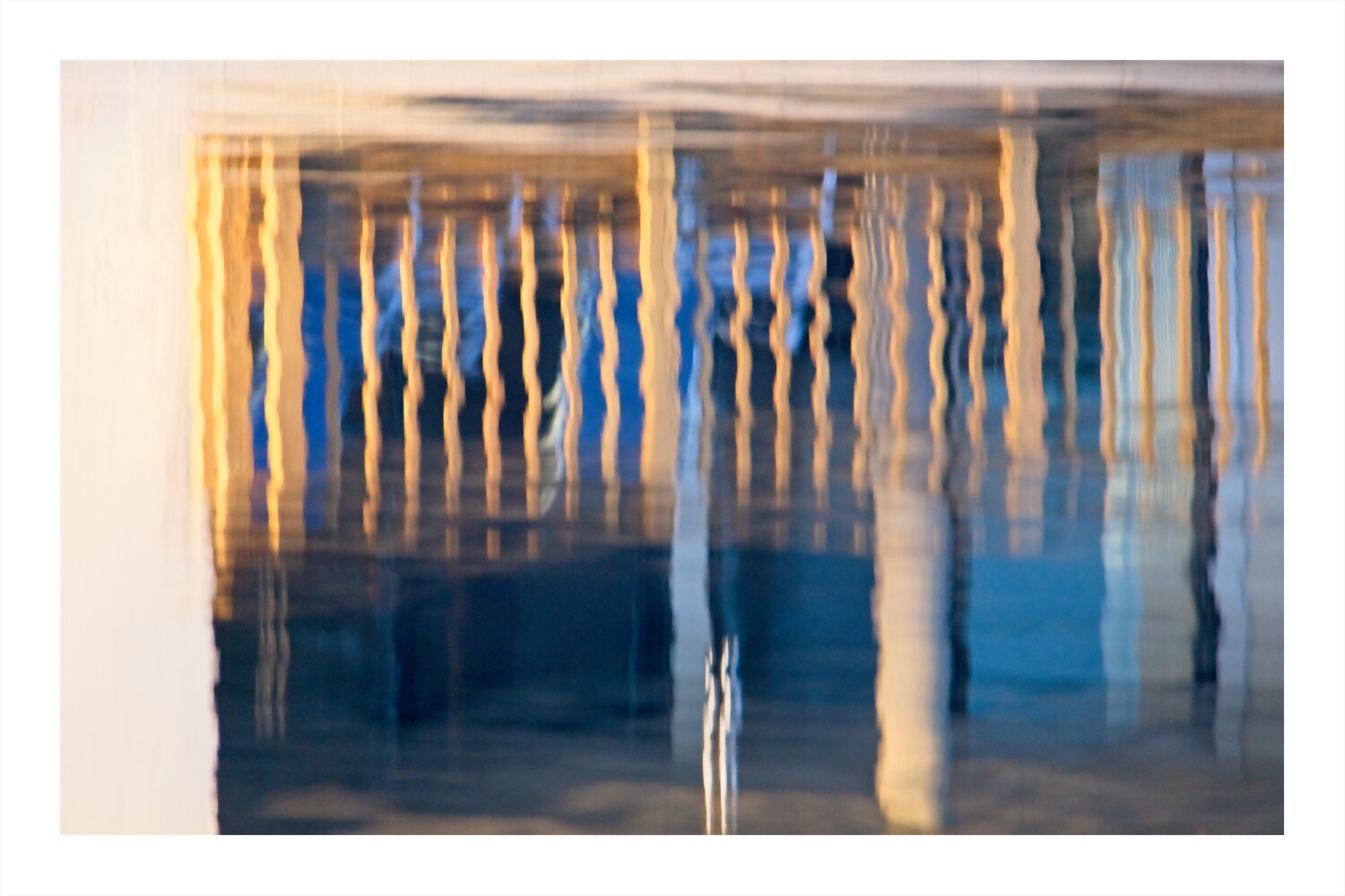 Abstract architectural interior with vertical lines and layered shadows in blue and golden tones