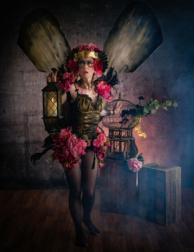 Woman adorned with pink flowers and vintage objects in surreal composite portrait
