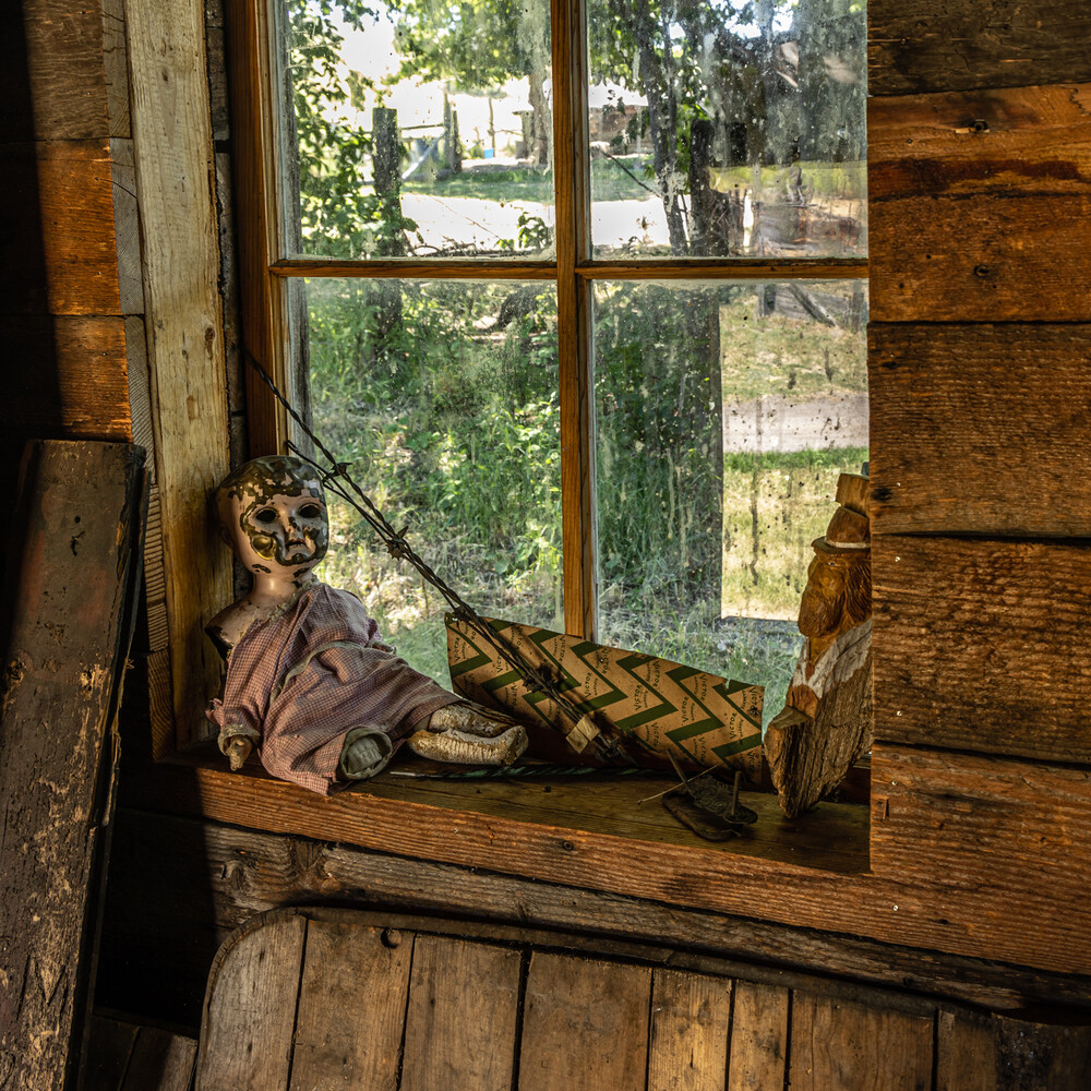 Person in period costume lounging on wooden windowsill with landscape view