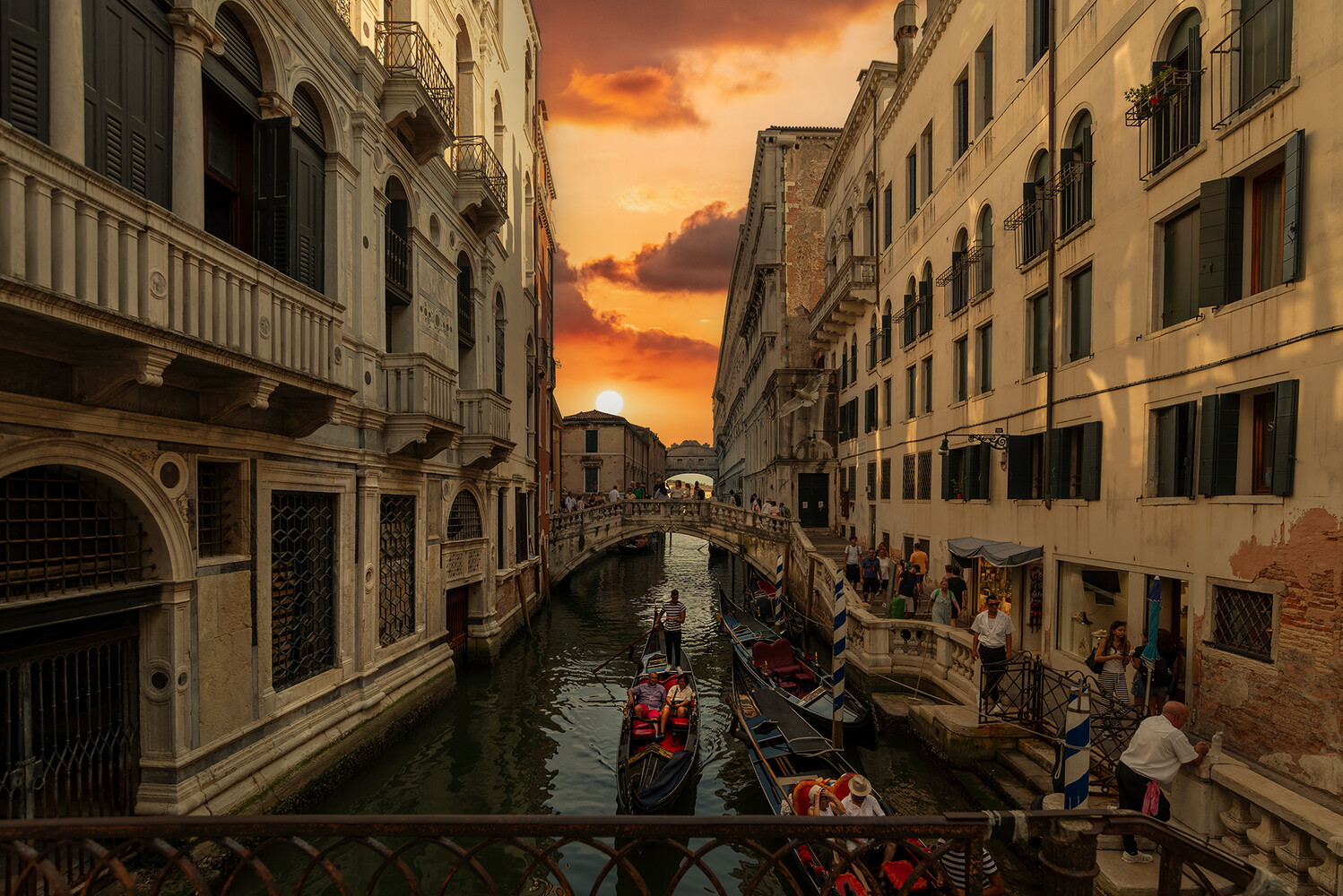 Gondolas on a Venice canal at sunset with Renaissance architecture lining both sides