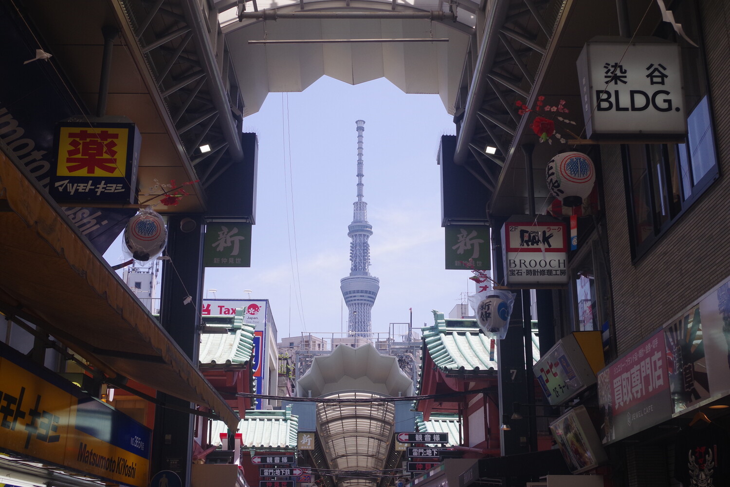 Tokyo Skytree framed through a covered shopping arcade with Japanese signage