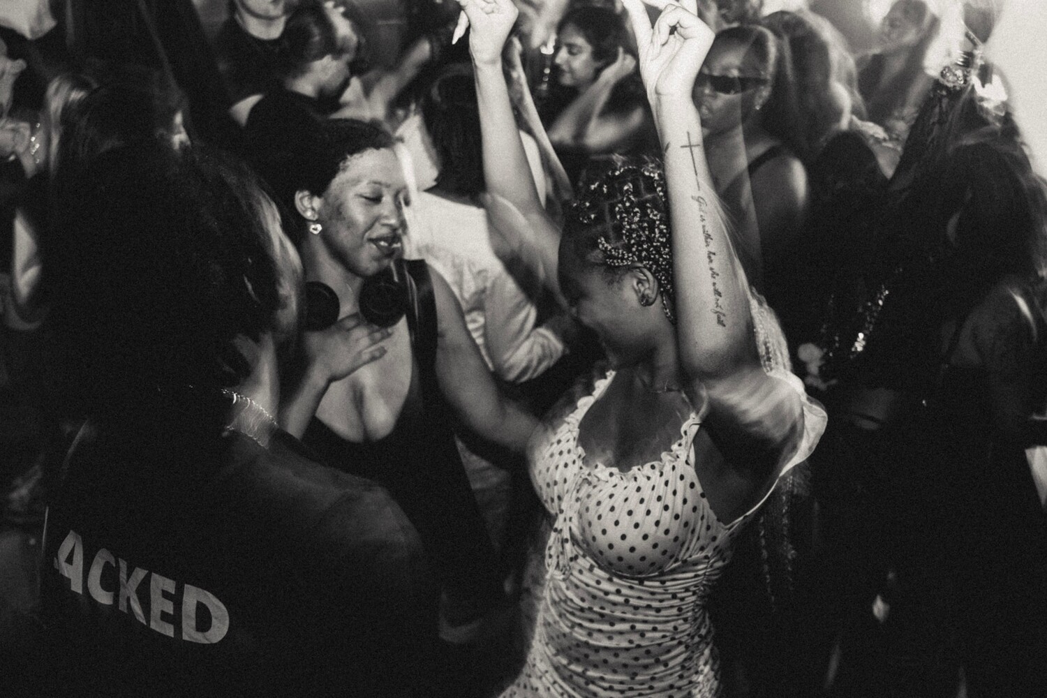 Black and white photograph of people dancing together at a crowded social gathering