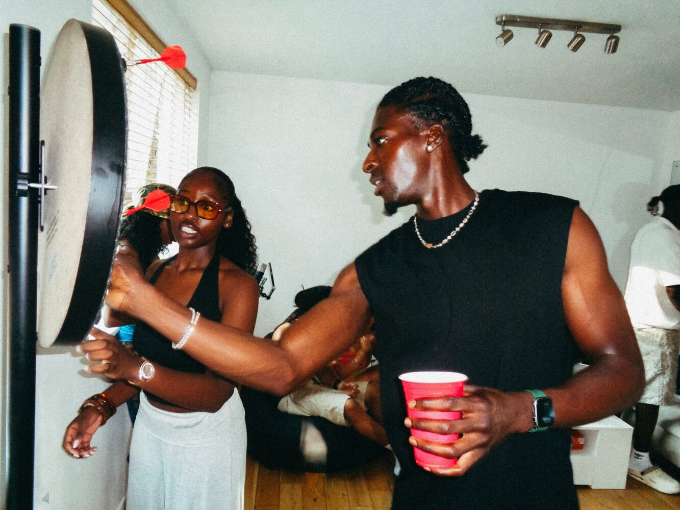 Two people in a kitchen holding red cups during a casual gathering