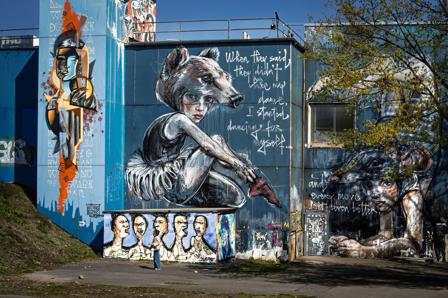 Large-scale street mural featuring a monochromatic portrait of a contemplative figure with handwritten text overlays