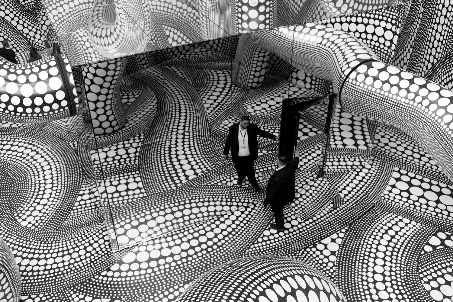 Silhouetted figure standing in geometric black and white patterned space