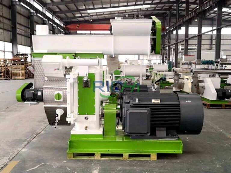 Industrial green and white pellet mill machine with motor assembly in factory warehouse