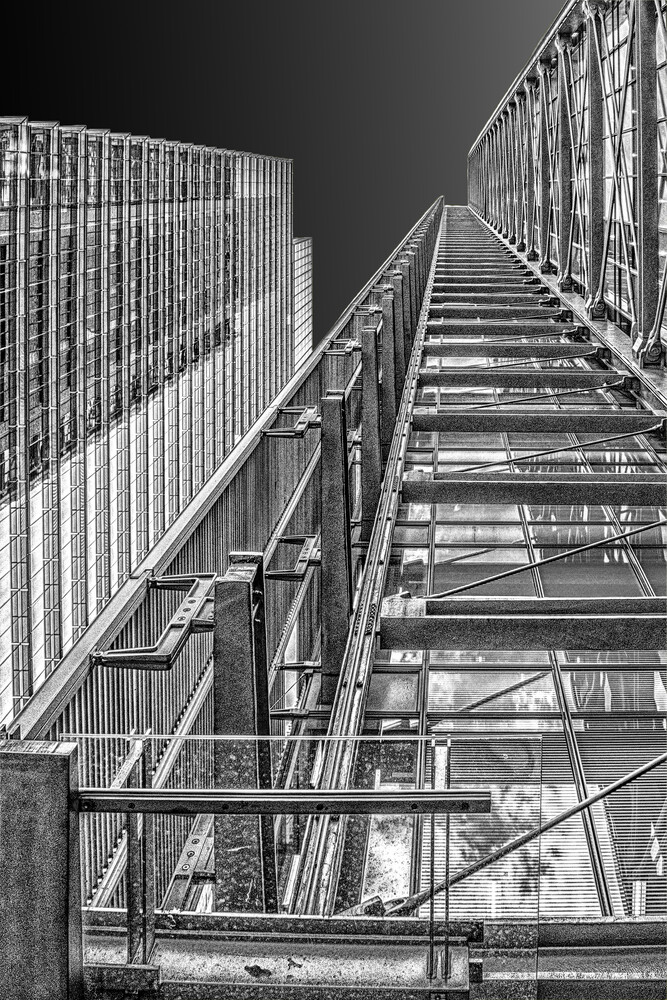 Steep metal staircase ascending into darkness, shot from below with strong geometric perspective