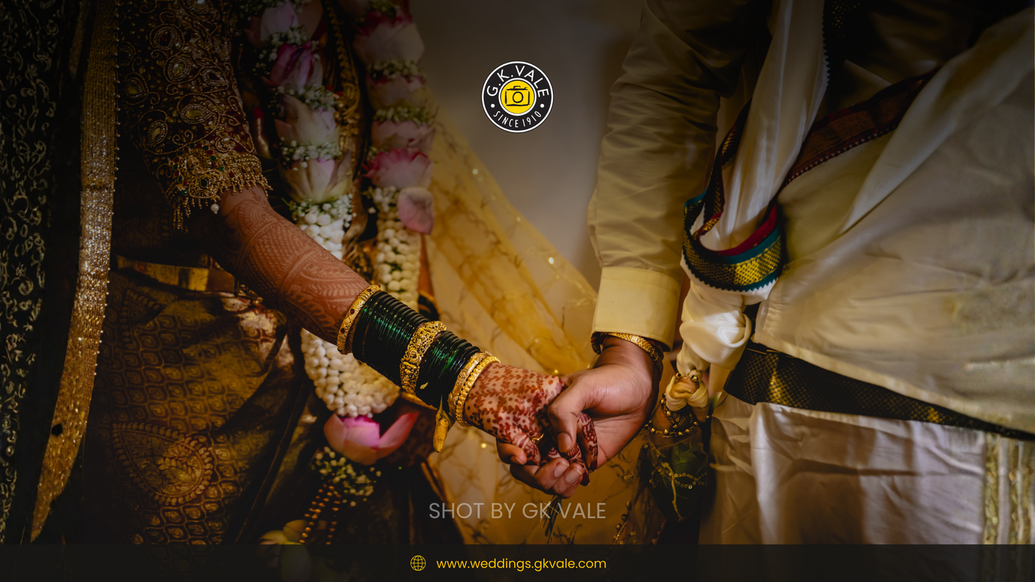 Bride and groom holding hands during wedding ceremony, showing henna, bangles, and traditional attire