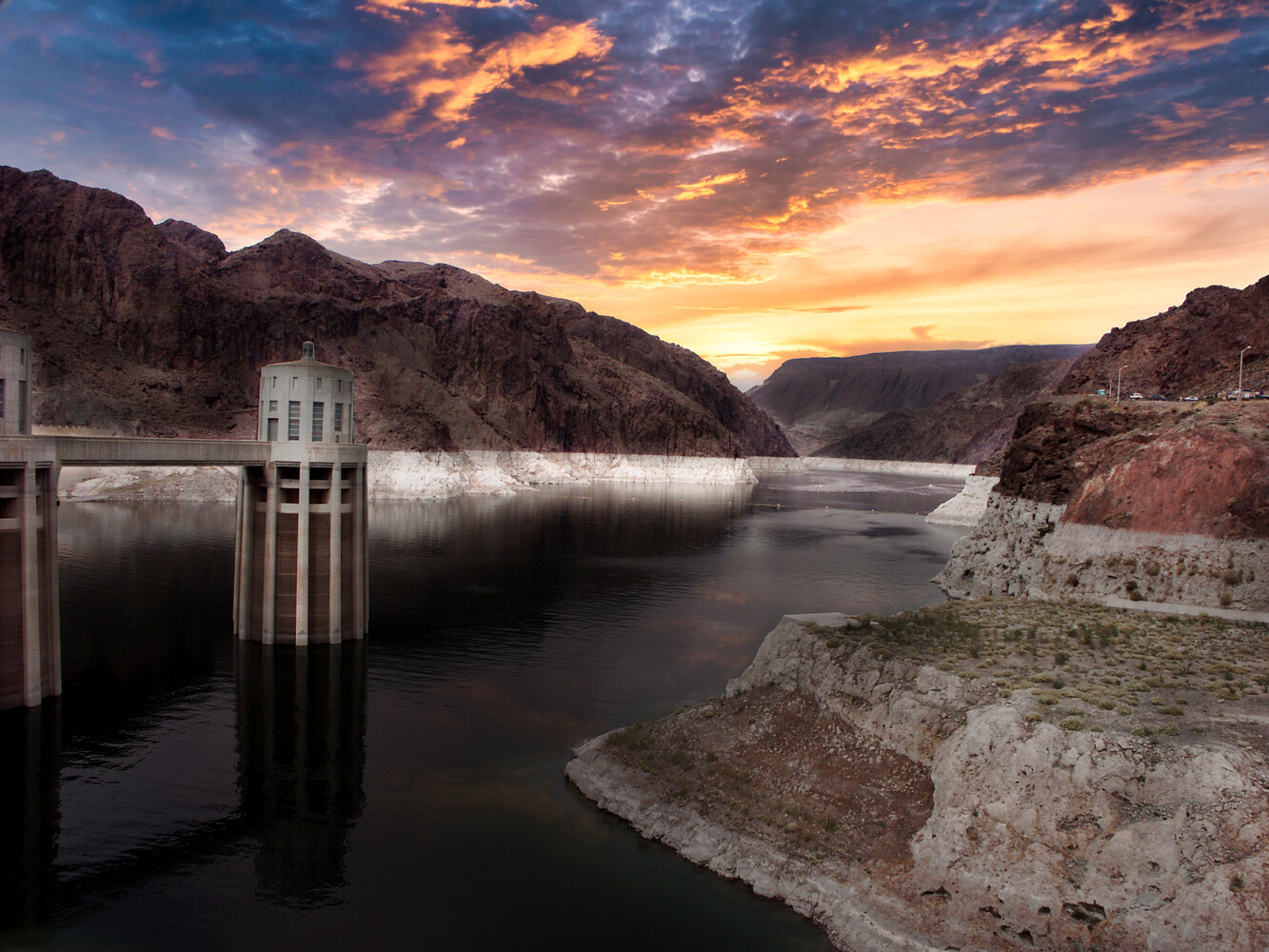 Hoover Dam intake towers at sunset with Lake Mead and desert mountains