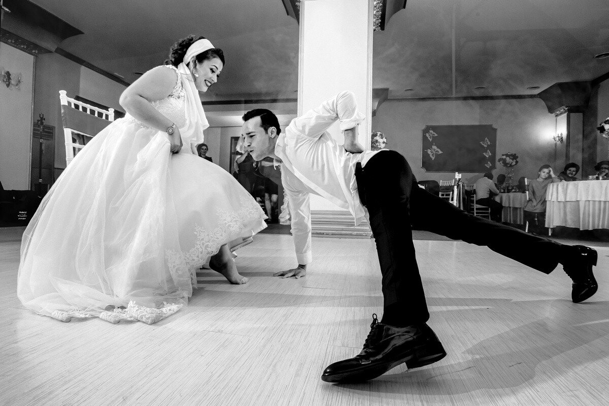 Groom dipping bride during first dance at wedding reception in black and white
