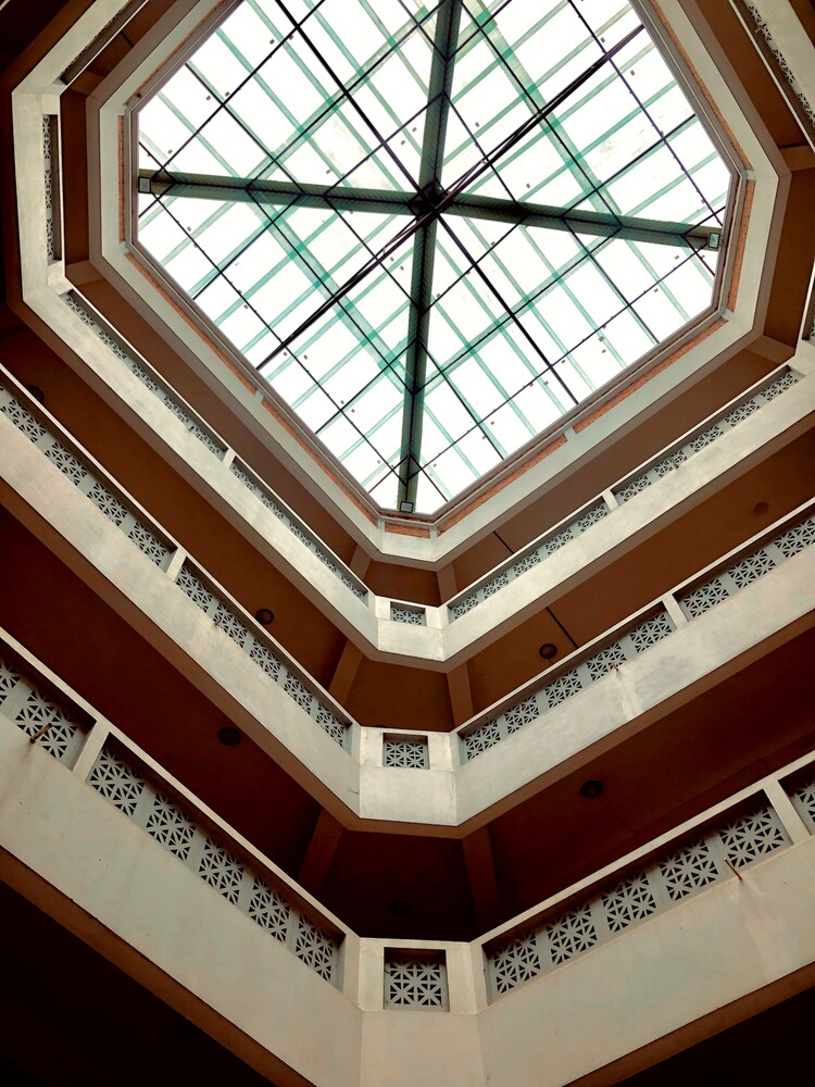 Octagonal skylight with geometric green cross pattern viewed from directly below