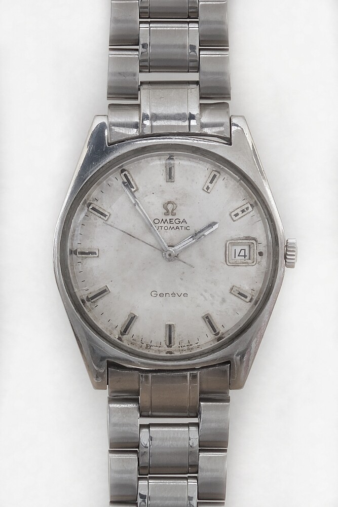 Vintage stainless steel wristwatch with silver dial and date window, photographed straight-on against white background