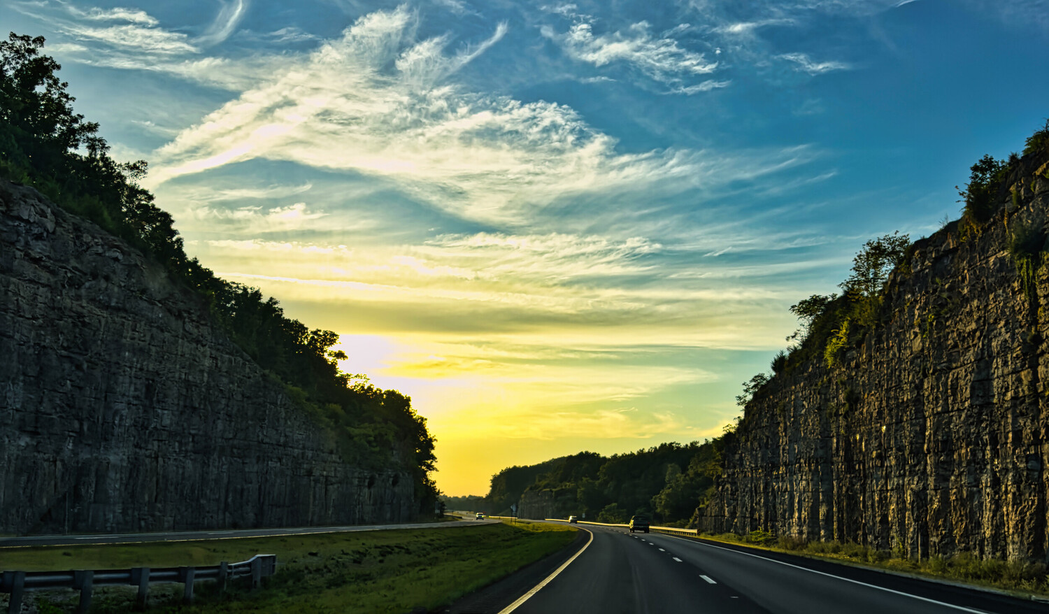 Highway stretching through basalt column formations at sunset