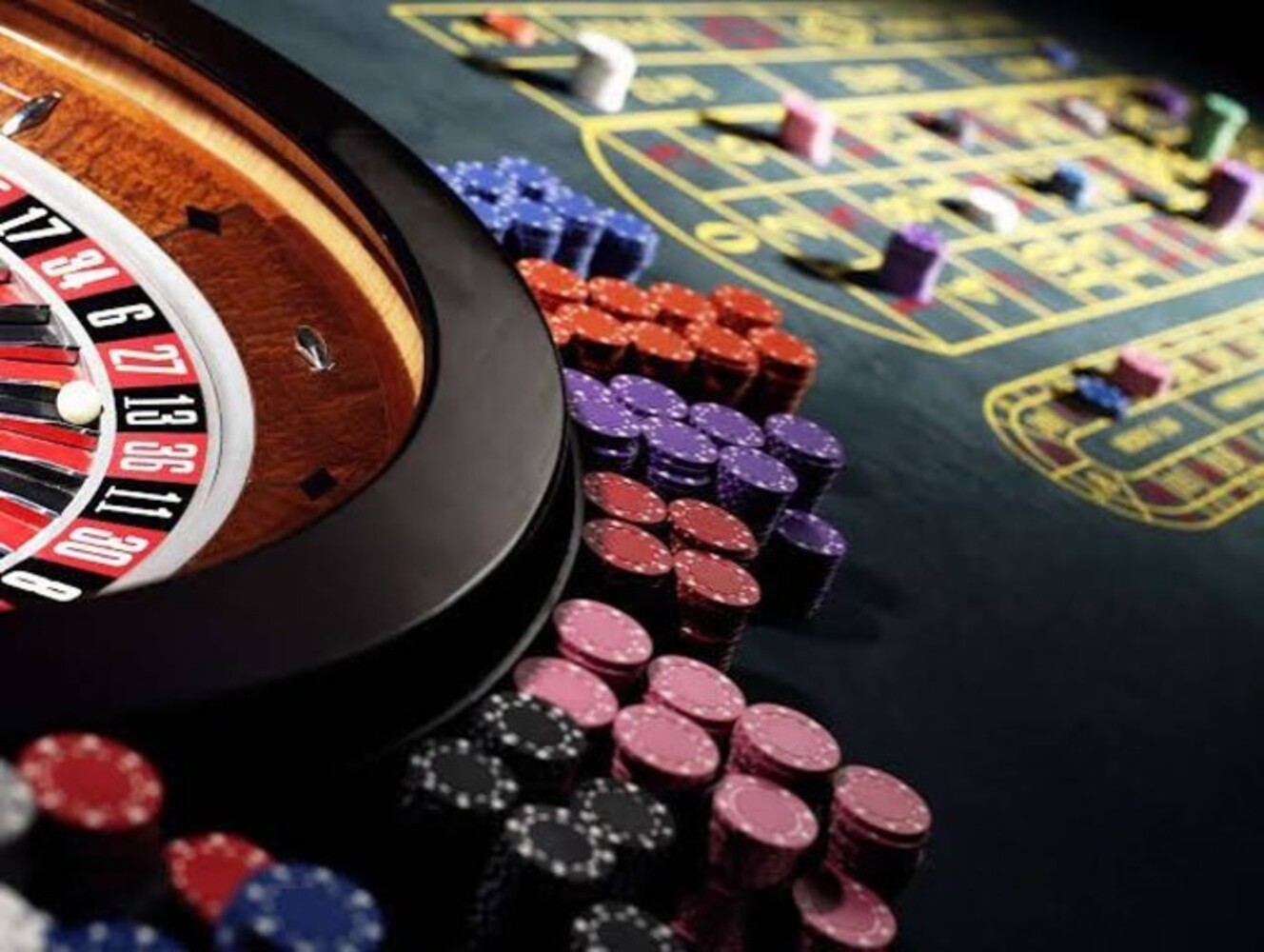 Roulette wheel and casino chips arranged on a gaming table with betting layout