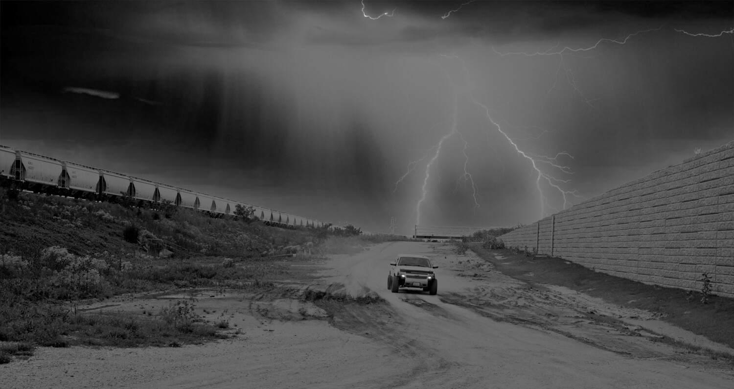 Lone vehicle driving on desert road beneath dramatic lightning strike during storm