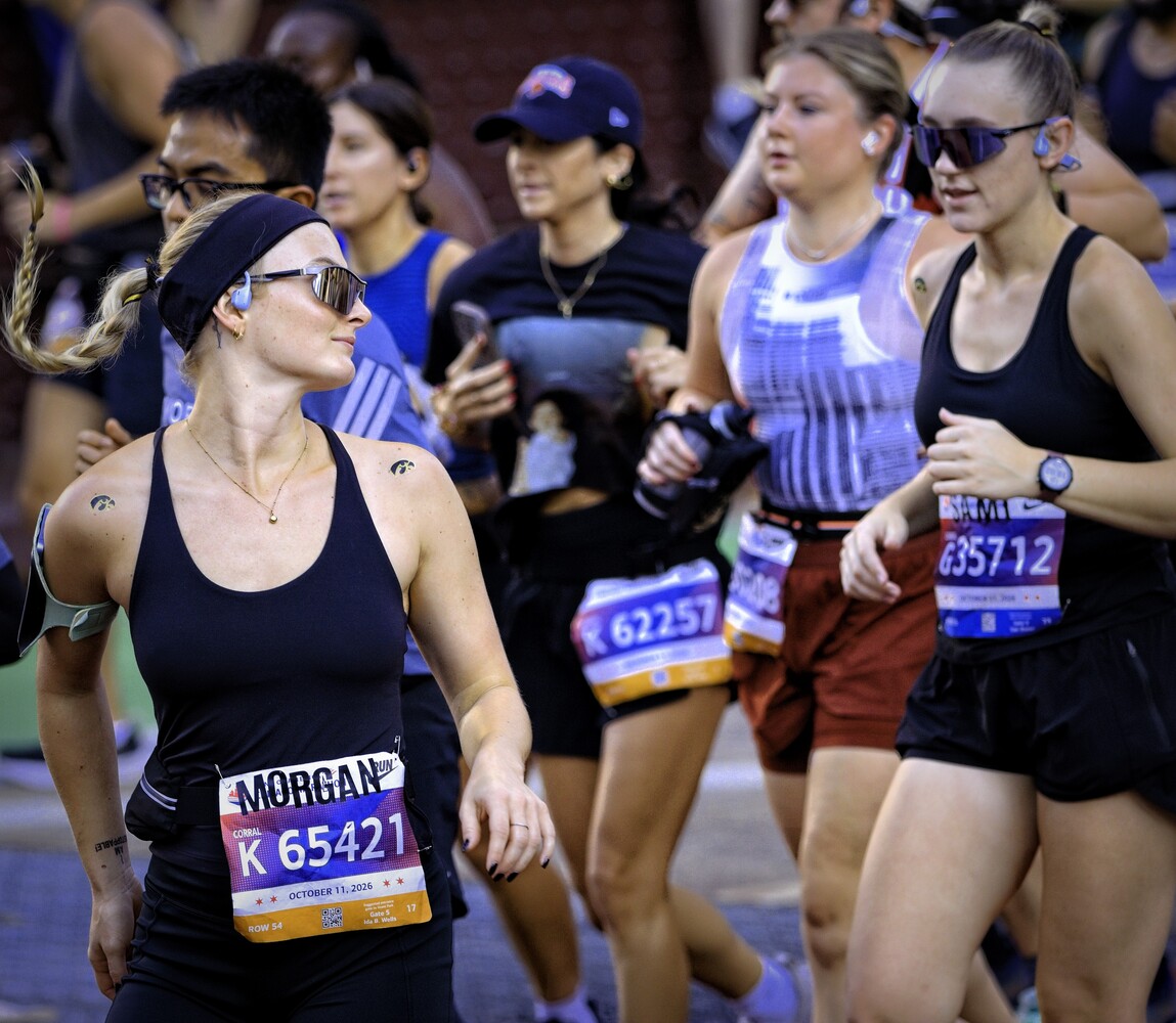 Female runners with race bibs jogging during an organized running event at night