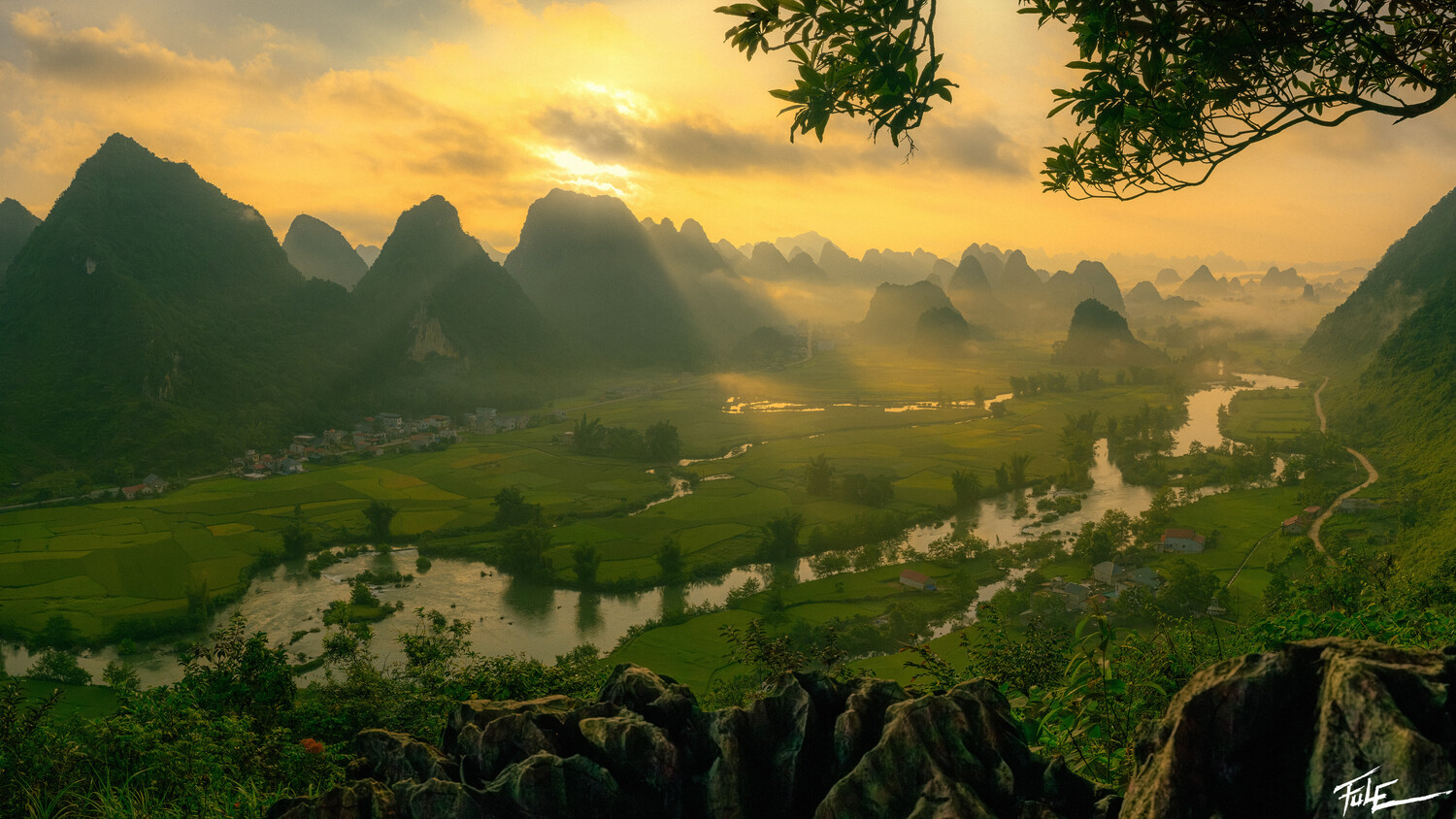 Karst mountain landscape at golden hour with winding river and mist