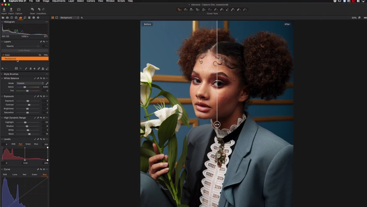 Portrait of a person with voluminous natural hair holding white flowers against a blue and orange background.