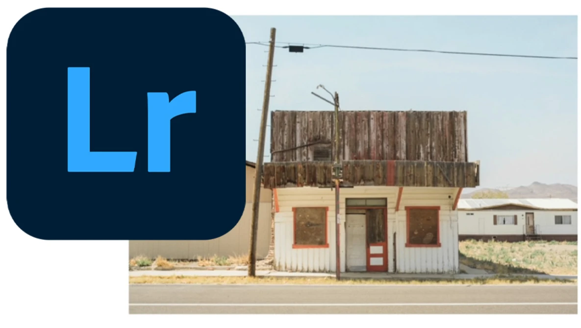 Abandoned roadside building with weathered wooden upper structure and faded storefront in desert landscape.