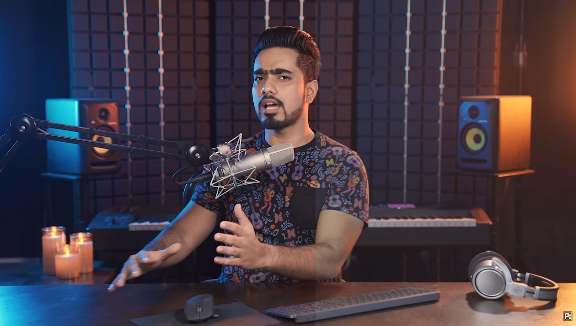 Male podcaster speaking into a large-diaphragm microphone in a professionally lit recording studio.