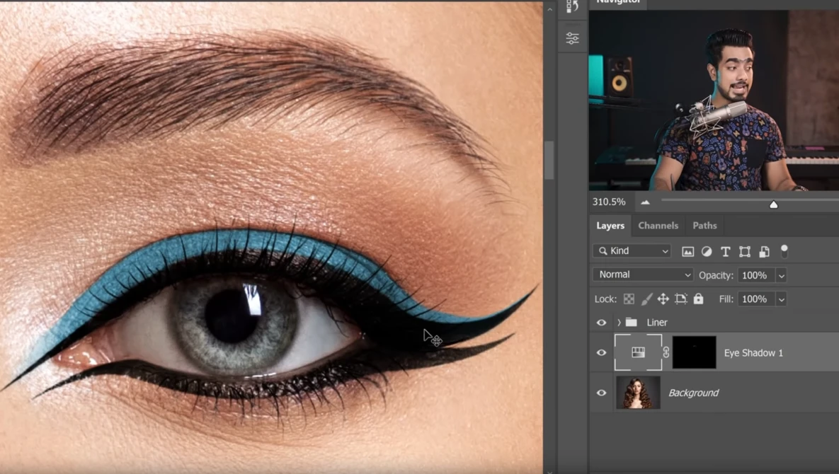 Close-up of eye makeup with bright turquoise eyeliner and winged black liner on fair skin.