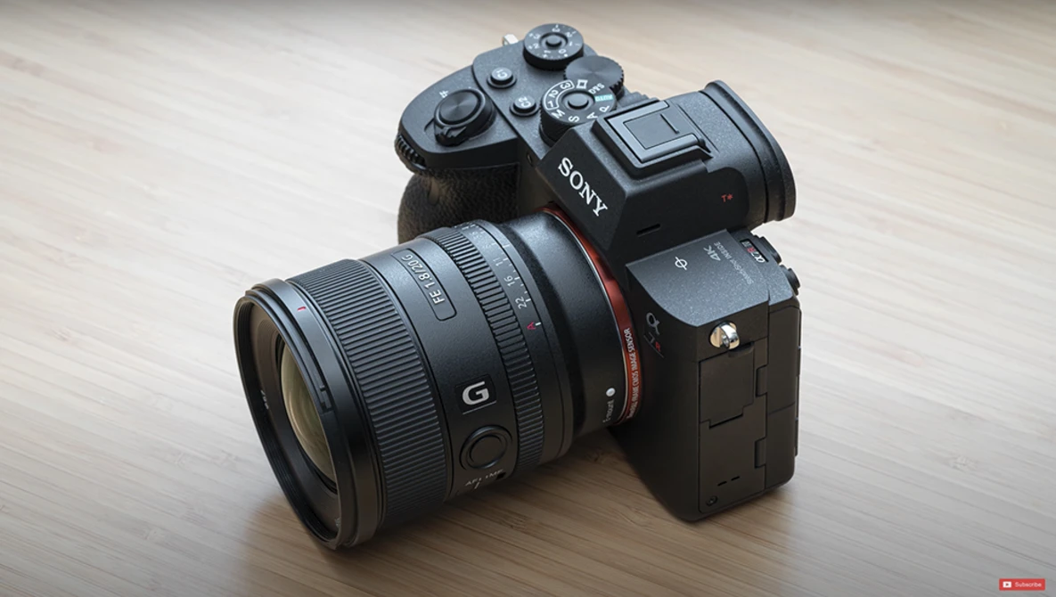 Sony mirrorless camera with Sony G-series lens mounted, displayed on light wood surface.