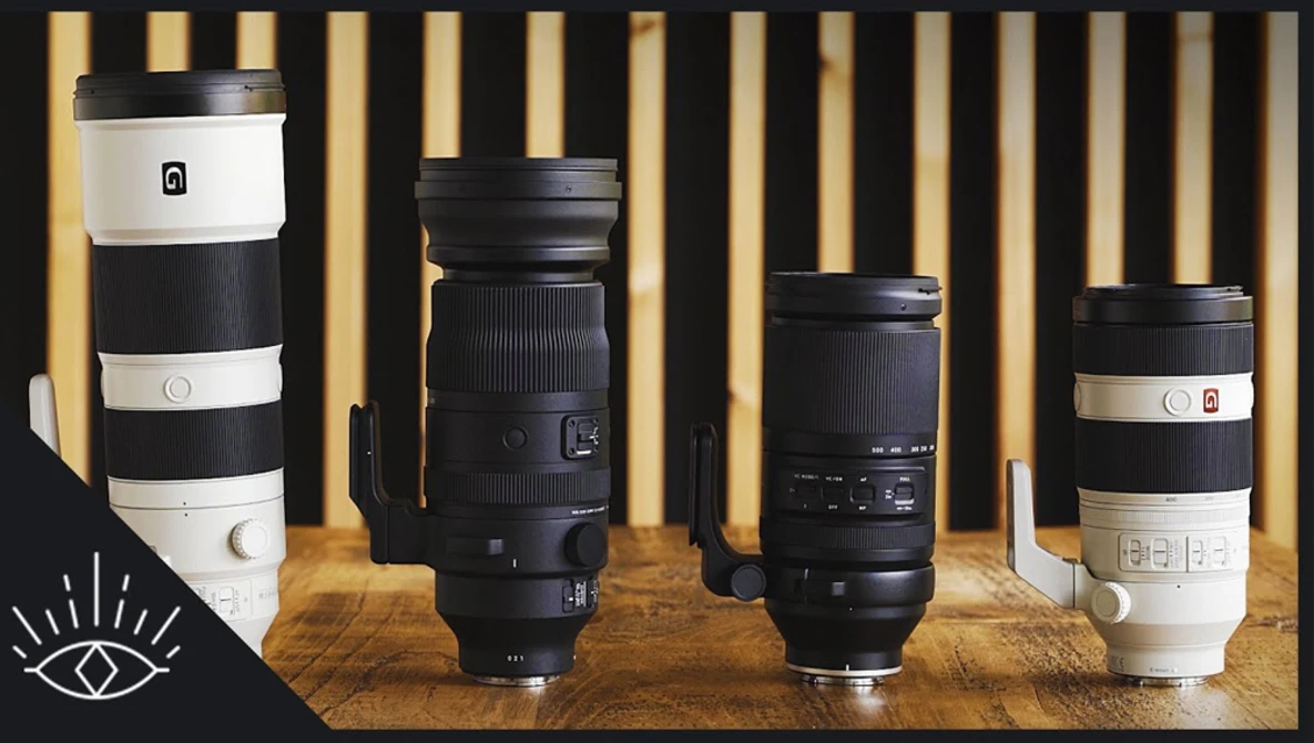 Four telephoto lenses arranged on a wooden surface against a striped gold and cream backdrop.