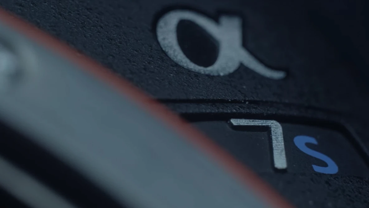 Close-up of camera body showing manufacturer logo and camera model designation with selective focus.