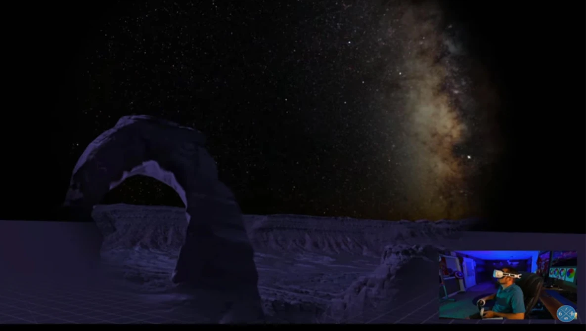 Night sky photograph showing the Milky Way above an illuminated dome structure with a person visible in the foreground.