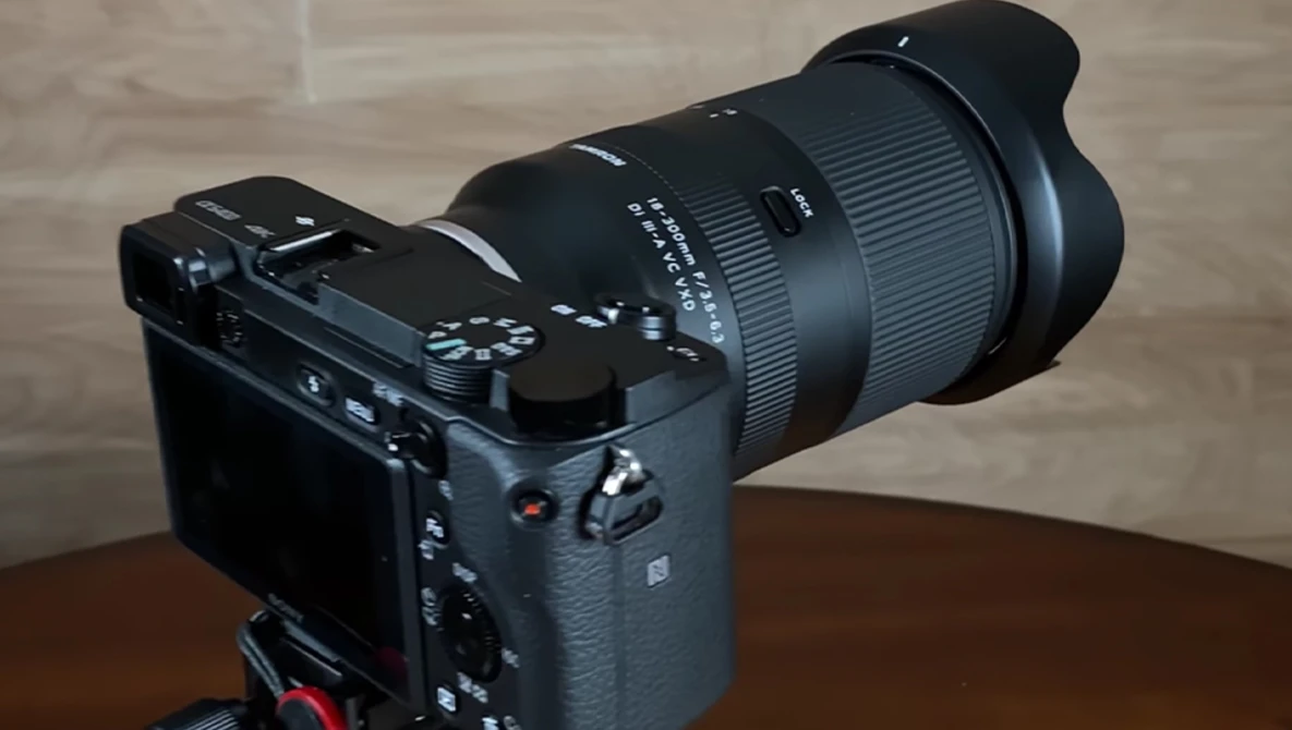 Mirrorless camera with wide-angle zoom lens mounted on wooden table.