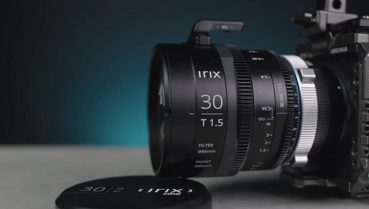 Irix 30mm T1.5 cinema lens mounted on a camera body against a teal and gray background.