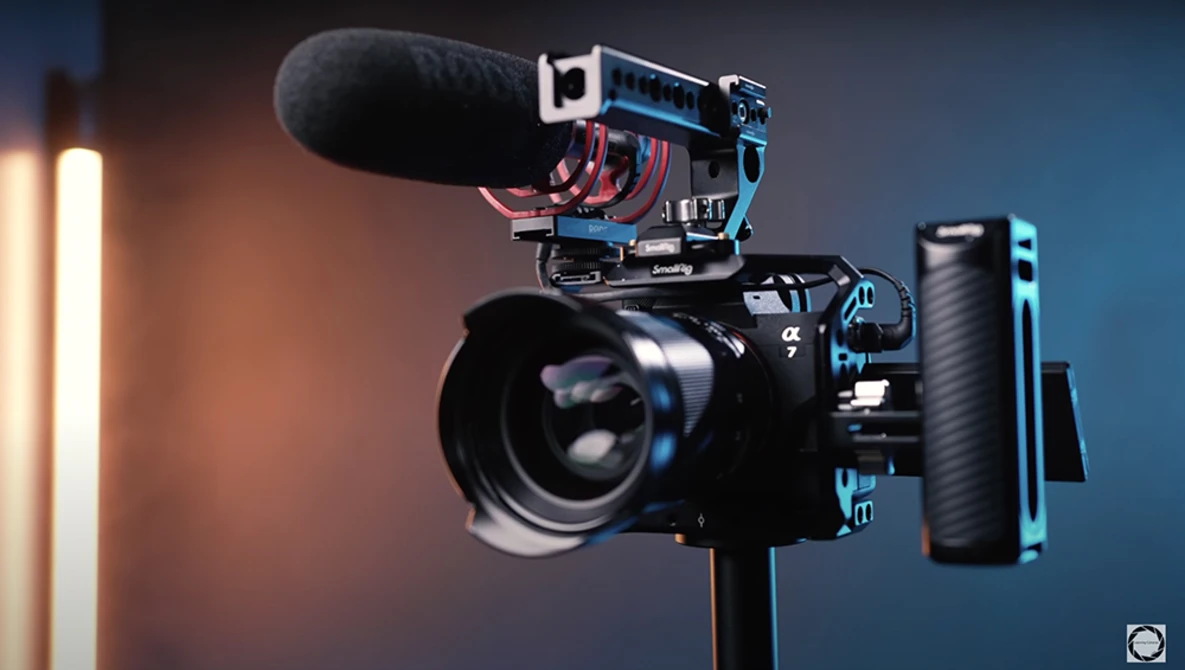 Professional mirrorless camera rig with shotgun microphone, wireless receiver, and follow focus system mounted on tripod.
